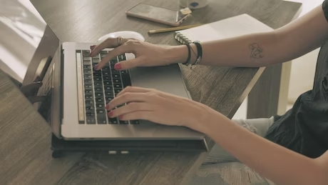 在计算机上工作的女孩的手